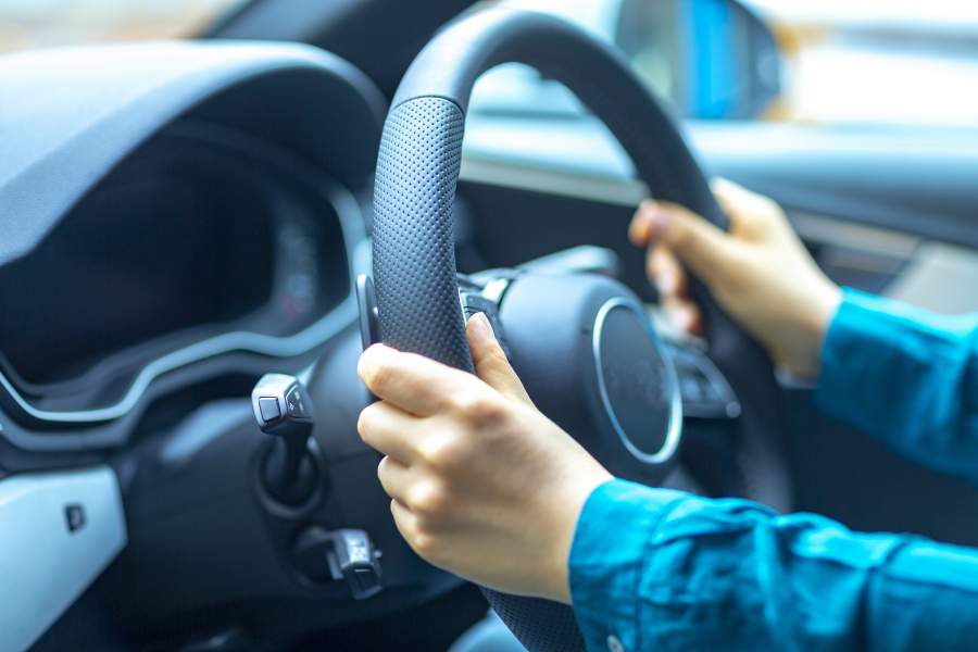 Les mains sur le volant d'une voiture pour une conduite sûre et sur la route